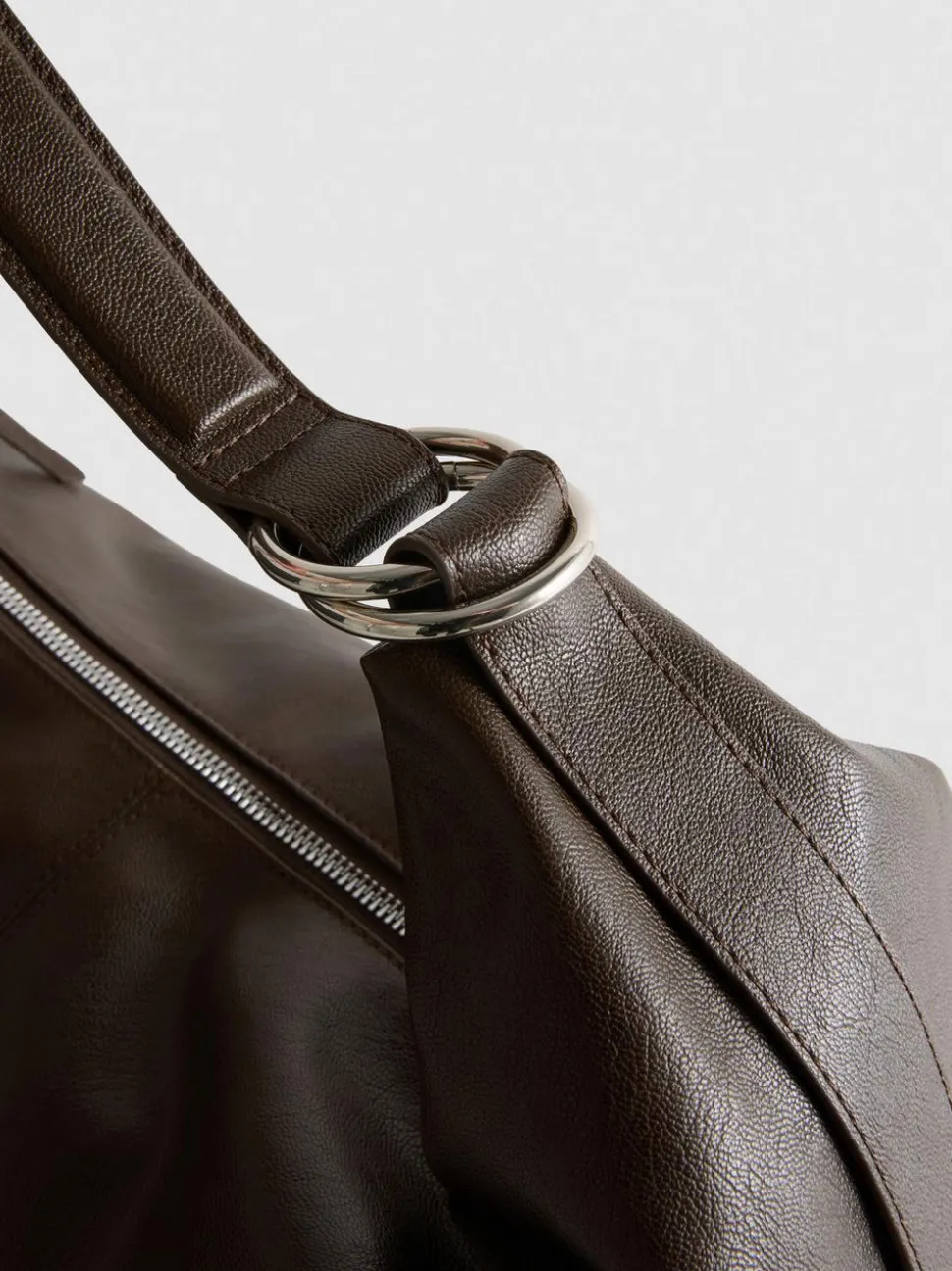Lässige Schultertasche mit Zierringen