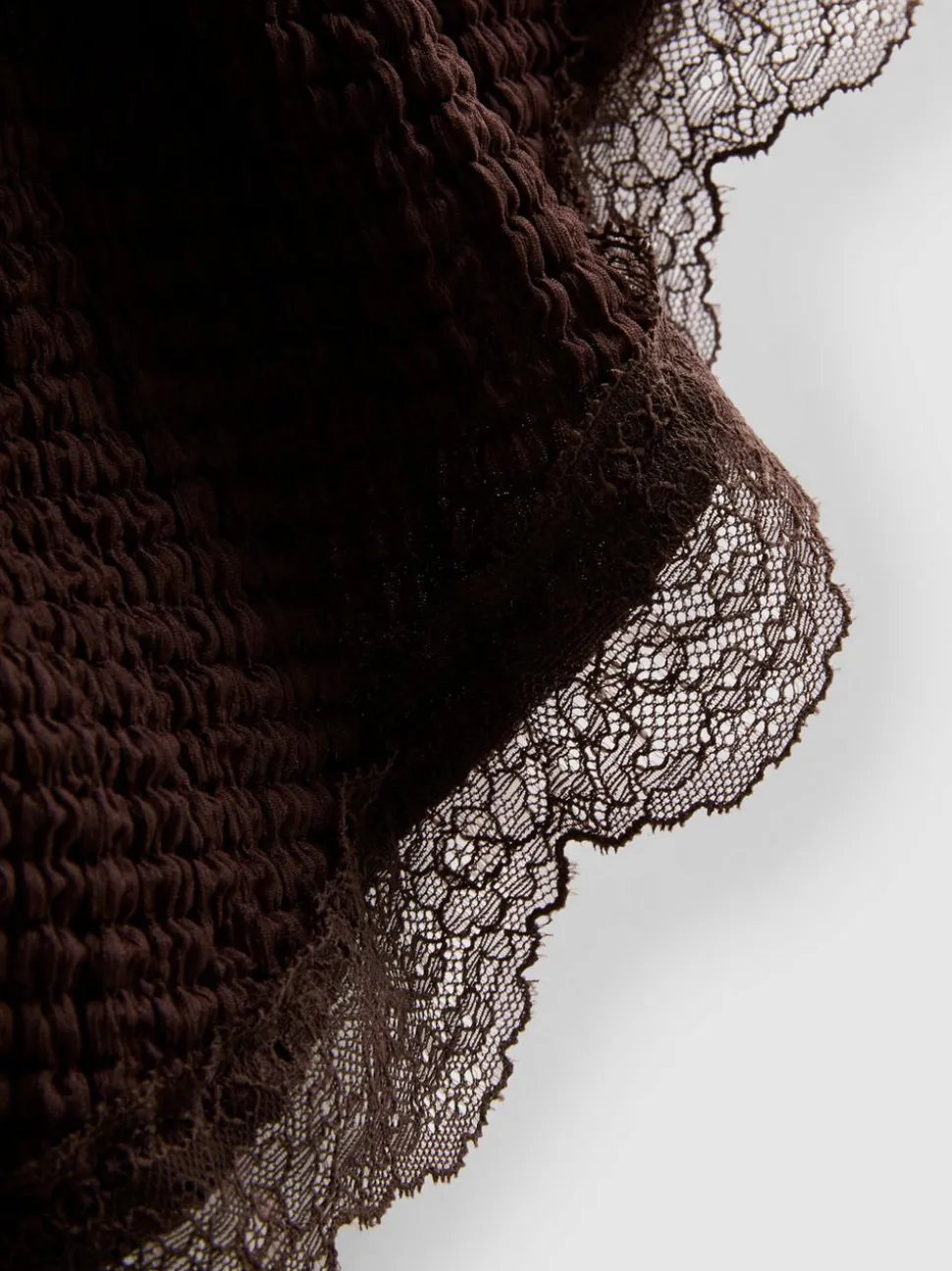 Strukturiertes, asymmetrisches Top mit Spitzenbesatz